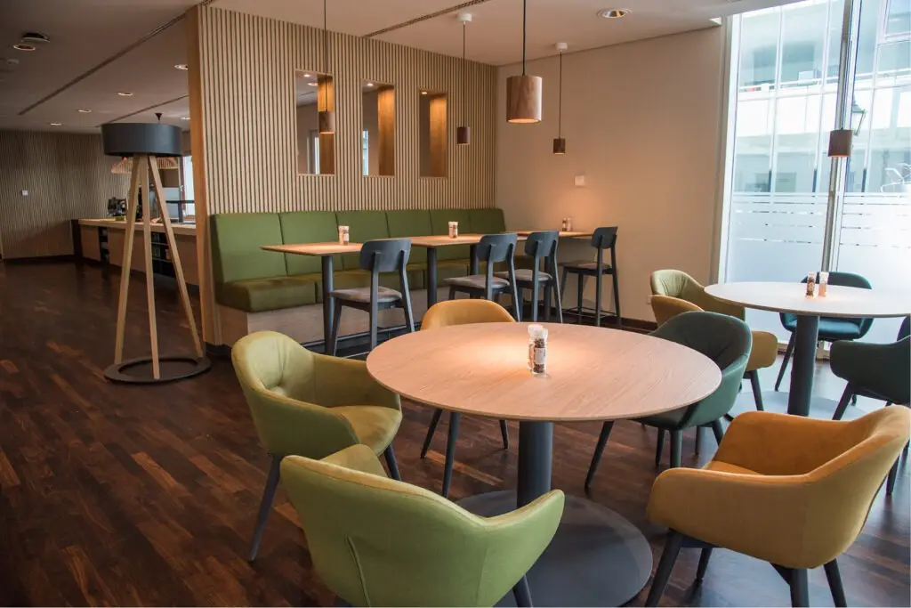 Möblierung, Stühle, Sessel Polsterbänke, Säulentische, Barhocker Campus-Restaurant Franz Haniel Duisburg, Schniedersitzt