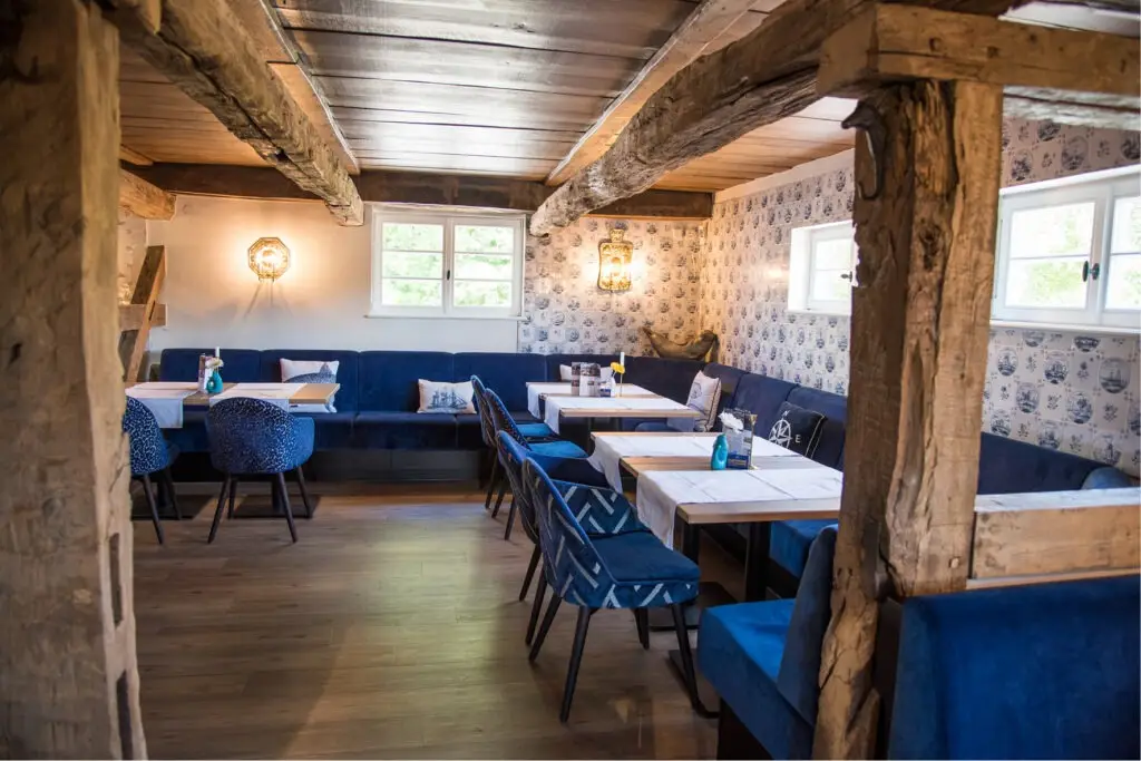 Möblierung Restaurant, Polstersessel Tina, Säulentische Polsterbänke Emmi, Fachwerk