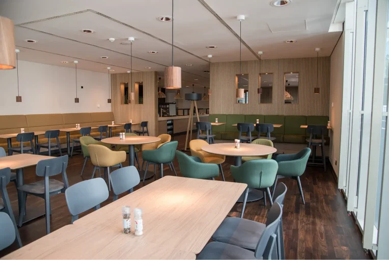 Möblierung, Stühle, Sessel Polsterbänke, Säulentische, Barhocker Campus-Restaurant Franz Haniel Duisburg, Schniedersitzt