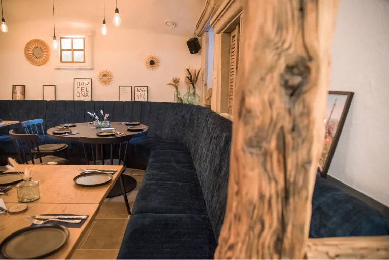 Polsterbank Emmi dunkelblau, runder Tisch, Einrichtung Möblierung Gastronomie Auszeit in Waltrop, Sessel Tina, Polsterbänke in dunkelblau, Säulentische, Holzstühle Mika in schwarz