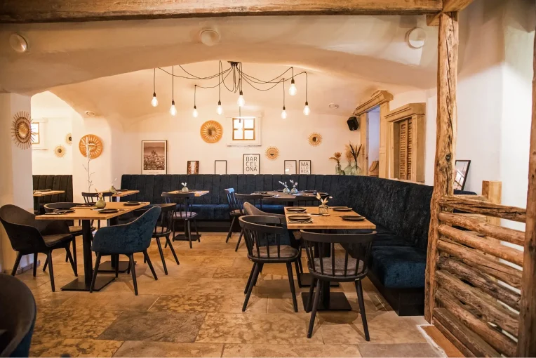 Einrichtung Möblierung Gastronomie Auszeit in Waltrop, Sessel Tina, Polsterbänke in dunkelblau, Säulentische, Holzstühle Mika in schwarz