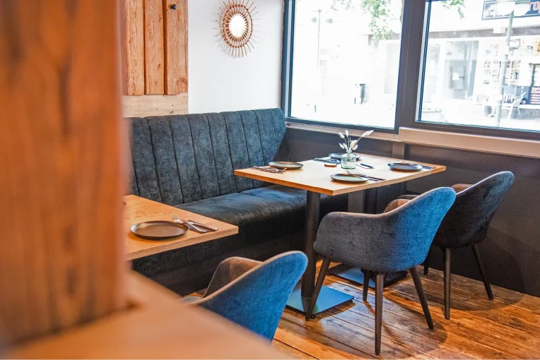 Polsterbank dunkelblau, Säulentisch, Sessel Tina, Einrichtung Gastronomie Auszeit,