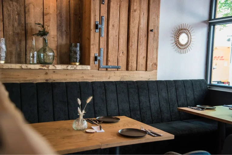 Polsterbank Emmi, dunkelblau, Einrichtung Möblierung Gastronomie Auszeit in Waltrop, Sessel Tina, Polsterbänke in dunkelblau, Säulentische, Holzstühle Mika in schwarz