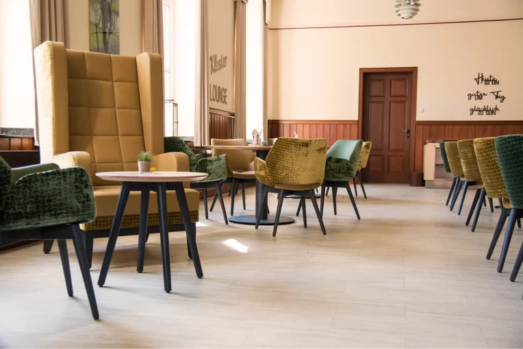 Fotos von der Einrichtung Seniorenheim Kloster Lounge Antoniushaus Lüdinghausen Schniedersitzt, Möblierung Esszimmer Aufenthaltsbereich, Ohrensessel, Sofa, Tische Polsterstühle