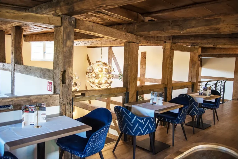 Möblierung Restaurant, Polstersessel Tina, Säulentische Polsterbänke Emmi, Fachwerk