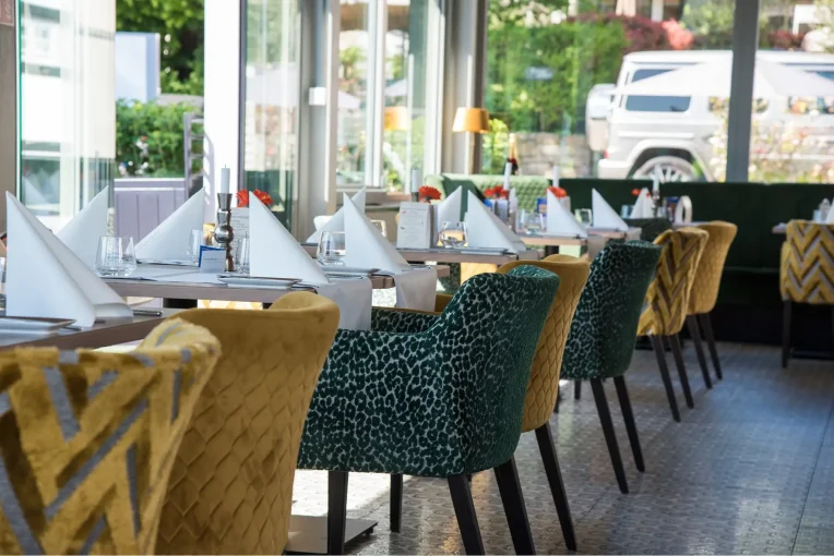 Möbel im Wintergarten Restaurant Rodenberg 1770, Polsterbank Emmi grün, Polstersessel Luisa in gelb und grün, Säulentische Christian
