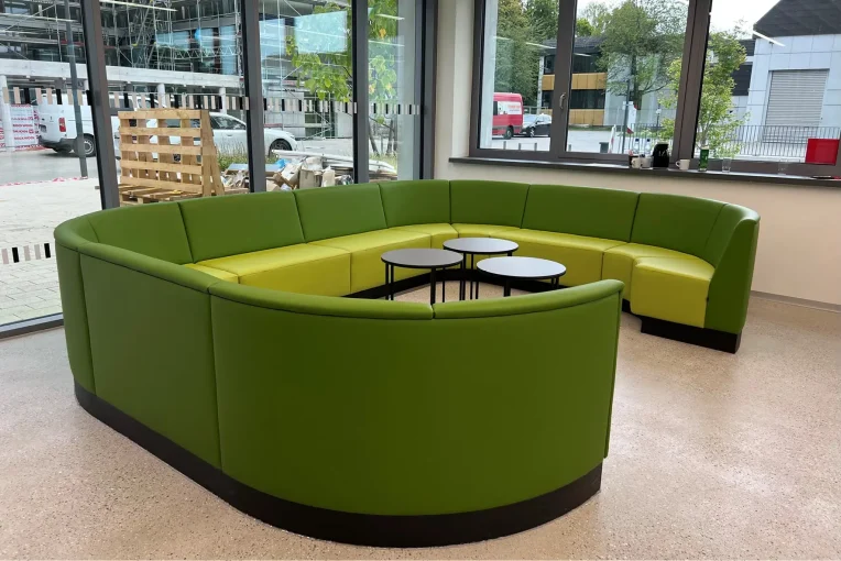 Foto von einer grünen Polsterbank im Sitzbereich Foyer Mensa Kantine Hochschule RheinMain Schniedersitzt Möbel für gute Gäste